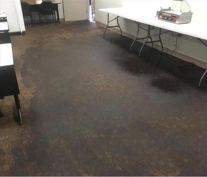 A room with wet carpet floors and tables