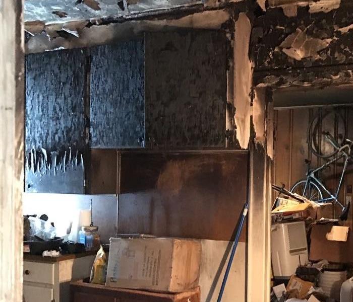 Photo of a kitchen that has been damaged from a fire on the stovetop