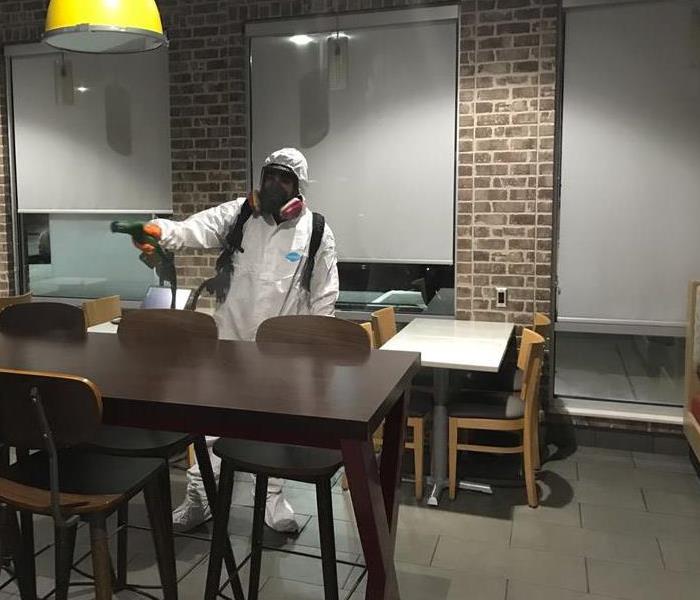 Fogging a business lobby, fully dressed in personal protective equipment